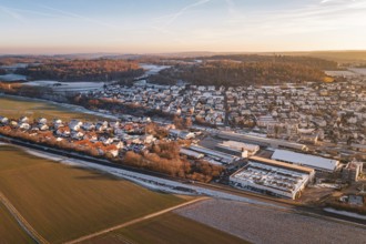 Aerial view of a settlement in winter surrounded by fields and roads, under blue sky, Althengstett,