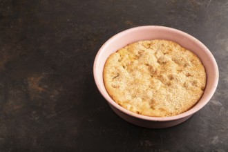 Apple Charlotte cake in baking dish on black concrete background, side view, copy space