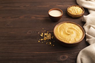 Pea cream soup, Puree, porridge in wooden bowl on wooden background and linen textile. Diet,