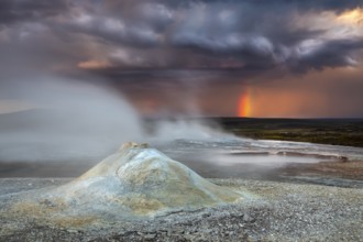 Thunderstorm and rainbow over the Hveravellir geothermal area with natural hot springs and