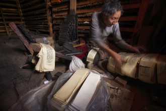A Tibetan prints the pages of sacred religious texts at the historic Tibetan Buddhist printing