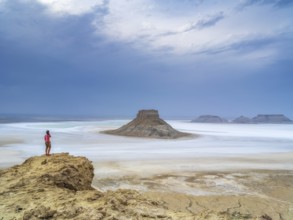 A tourist admires the inselbergs Karamaya and the Three Brothers (Three Batyrs), the Karagiye