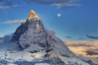 Sunrise with the moon over the Matterhorn (4, 478 m), one of the world's most iconic mountains,