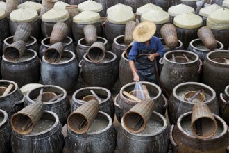 Washing the giant clay pots used for fish sauce fermentation at a factory in Xiapu, Fujian