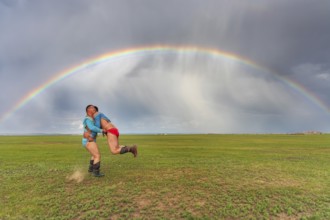Traditional Mongolian wrestling in summer under a rainbow, Mongolia, Asia
