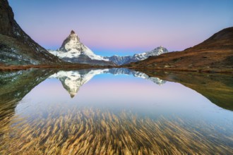 Matterhorn at 4, 478?m, iconic symbol of Switzerland, reflected in Riffelsee Lake at sunrise in
