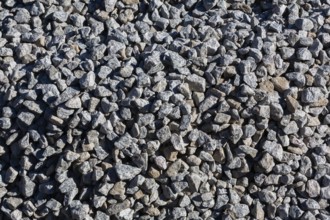 Close-up of grey crushed stone aggregate used to form a bed for constructing roads and driveways