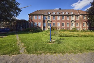 Town Hall, historic brick building, façade with windows, dormers, building sign, sidewalk, meadow,