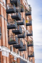 A building with numerous balconies and brick façade in an urban setting, London, England, Great