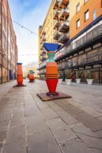 A sculptured street in an urban setting with a blue sky, London, England, Great Britain