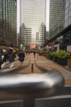 A busy walkway surrounded by tall modern skyscrapers and people walking, Canary Wharf, London,