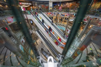 Colourful escalators in a multi-storey shopping mall with a lively atmosphere, London, England,