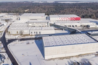Modern industrial buildings in a snowy landscape surrounded by forest, Häfele, Nagold, Germany