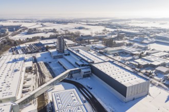 Large aerial view of snowy industrial complex under clear sky showing modern architecture, Häfele,