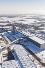 Aerial view of a snowy industrial area with several modern buildings on a clear winter day, Häfele,
