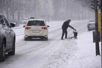 Senior with walker during heavy snowfall, winter, Germany
