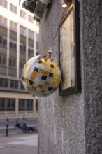 A decorative silver-gold ball hangs on a house wall, London, England, Great Britain