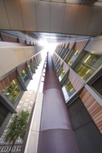 A symmetrical upward look between two modern buildings, London, England, Great Britain