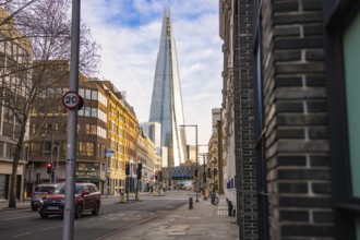 View of The Shard in London between city buildings under blue sky, London, England, Great Britain