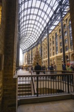 A shopping mall interior with a big Christmas tree and lots of people, London, United Kingdom
