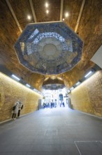 An artistically designed brick vault with lettering and people in an urban space, London Bridge