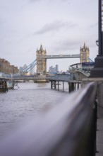 Historic bridge with towers over a river with an urban skyline in the background, Tower Bridge,