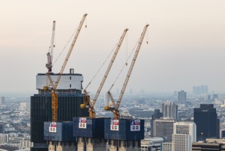 Over the rooftops of Bangkok, construction of a new high-rise building with construction cranes,