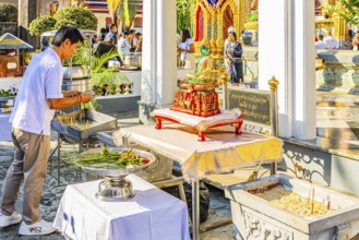 The Grand Royal Palace, Wat Phra Kaeo Buddhist Temple, believers bring flowers as offerings, Phra