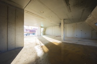 Unfinished room with concrete walls, light and shadow on the floor, carpentry, renovation, roof