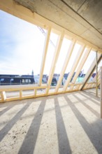 Timber structure of a roof truss with shadows under a clear sky, carpentry, renovation, roof