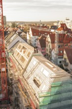Urban construction on a roof with a crane and surrounding houses, carpentry, renovation, roof