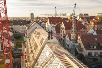 View of urban construction site in an old town with crane and roof work, carpentry, renovation,