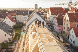 Workers on a new roof with a view of a colorful urban environment, carpentry, renovation, roof