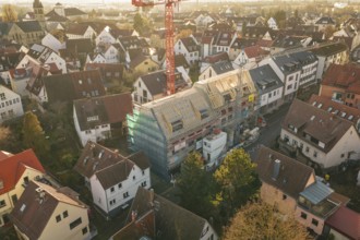 Aerial view of an urban residential area with a visible construction site and a crane, carpentry,