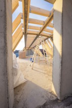 Interior construction site with wooden structure and ladder under incoming daylight, carpentry