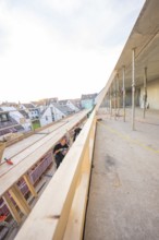 Worker on a construction site looking at residential buildings and the half-finished interior,