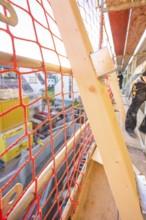 Close-up of a red safety net on scaffolding on a construction site, carpentry construction, roof