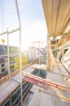 View from above of a construction site with scaffolding at sunset. Urban environment visible,