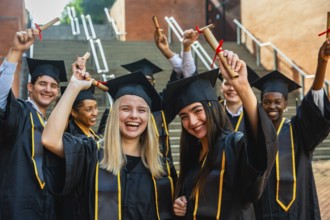 Group of happy diverse university students graduating, celebrating their academic achievement