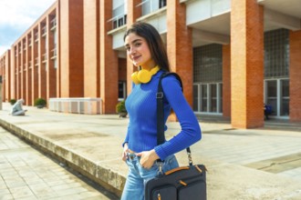 Young female student smiling, looking at the camera, and posing with her headphones around her