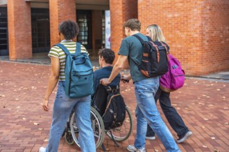 University students walking together with a classmate using a wheelchair, showing friendship and