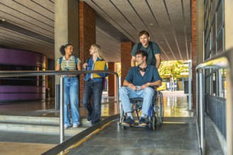 Young diverse students collaborating, navigating a modern university building ramp, showing
