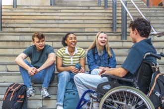Diverse group of young adult university students laughing and interacting while sitting on campus