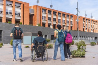 Diverse group of college students, including one using a wheelchair, walking together on a modern