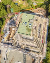 Bird's eye view of a building under construction in a green city scene, carpentry construction