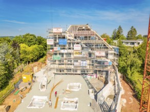 Large construction site with scaffolding around a multi-storey building and building materials on