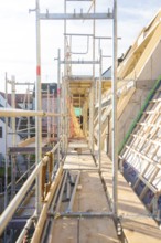 A long corridor with scaffolding on a construction site with wooden structures, carpentry