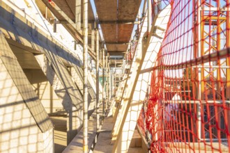 A scaffolding with wooden panels and casting shadows on a construction site, carpentry