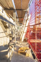 A scaffolding with wooden panels and casting shadows on a construction site, carpentry
