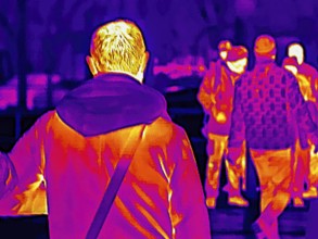 Thermal image or thermography, symbolic photo, interpolated. People traveling in urban areas.